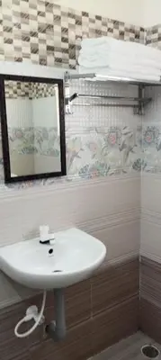 a bathroom with a sink and a mirror at Sri Annapoorna Luxury Apartment - Serviced Apartment in Coimbatore