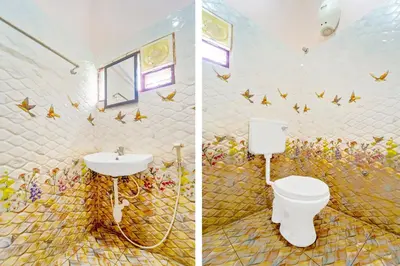 a bathroom with a toilet and butterflies on the wall at Super Hotel O Ganapathy Athipalayam Pirivu Road in Coimbatore