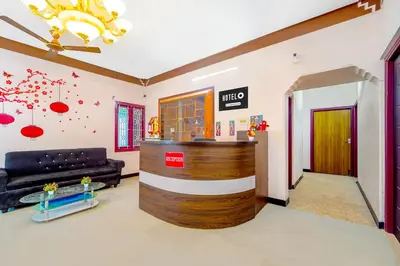 a living room with a couch and a lobby at Super Hotel O Ganapathy Athipalayam Pirivu Road in Coimbatore
