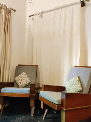 a room with two chairs and a window at Garden Home mindfully laid out & furnished in Mysore