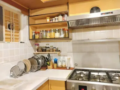 a kitchen with a stove and a counter top at Garden Home mindfully laid out & furnished in Mysore