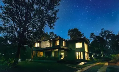 a house at night with the lights on at Coorg Wild Walk, Nagarhole - A CGH Earth SAHA Experience in Srimangala