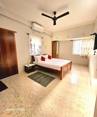 a bedroom with a bed and a ceiling fan at Urban Suites in Coimbatore