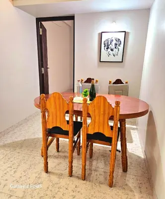 a dining room table with two chairs and a wooden table at Urban Suites in Coimbatore