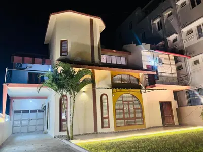 a large house with a palm tree in front of it at Majestic Villa 5 Bedrooms AC Bunglow in Mysore