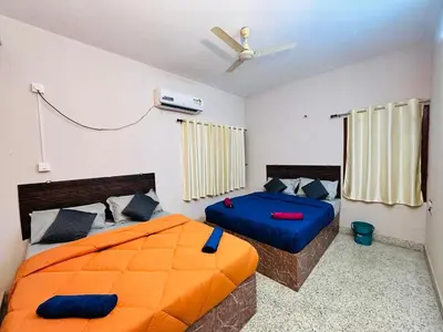 a bedroom with two beds and a ceiling fan at Majestic Villa 5 Bedrooms AC Bunglow in Mysore