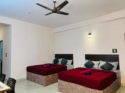 two beds in a bedroom with a ceiling fan at Majestic Villa 5 Bedrooms AC Bunglow in Mysore