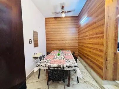 a table in a room with a wooden wall at Majestic Villa 5 Bedrooms AC Bunglow in Mysore