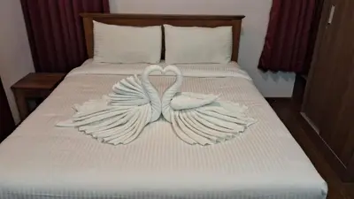 a bed with two swans made out of towels at Villa Bella in Ooty
