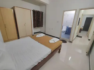 a bedroom with a bed with two towels on it at Dormitory Elite in Mysore