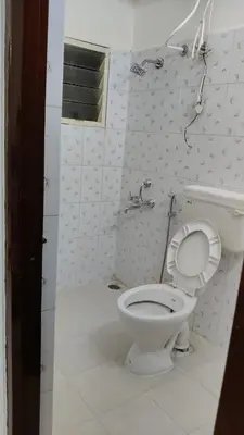 a bathroom with a white toilet and a sink at Dormitory Elite in Mysore