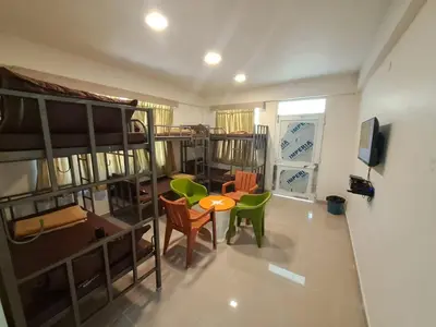 a room with bunk beds and a table and chairs at Labony House in Kodaikānāl