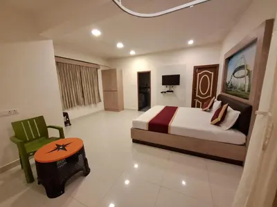 a bedroom with a bed and a green chair at Labony House in Kodaikānāl