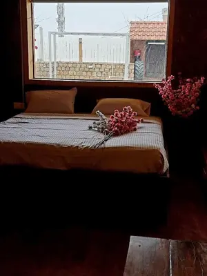 a bed in a room with a window with flowers on it at Woods inn in Coimbatore