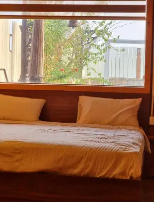 a bed sitting in front of a window at Woods inn in Coimbatore