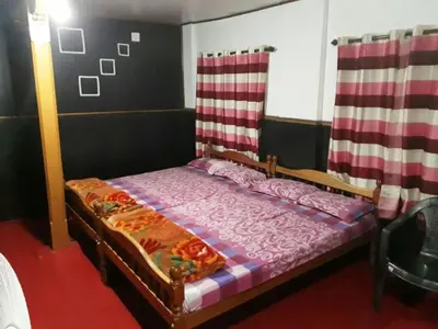 a bedroom with a bed with a purple comforter at RAOJI HomeStay in Vālpārai