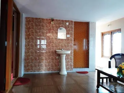 a bathroom with a sink and a brick wall at RAOJI HomeStay in Vālpārai