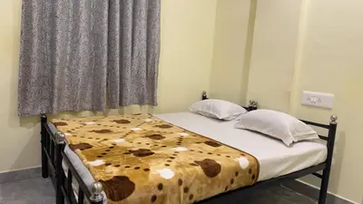 a bedroom with a bed with a brown and white blanket at StayIn-SGH near Mysore palace in Mysore