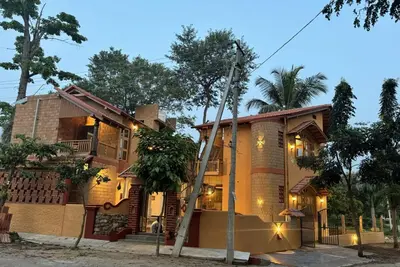 a house with a ladder in front of it at EcoMinimalist Home by the River in Seringapatam