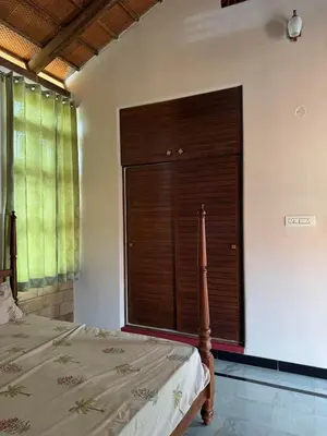 a bedroom with a bed and a large closet at EcoMinimalist Home by the River in Seringapatam