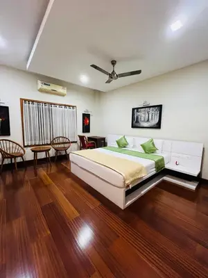 a bedroom with a large bed and wooden floors at Yemcee Rivera Homestay in Green Island