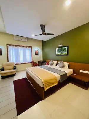 a bedroom with a bed and a green wall at Yemcee Rivera Homestay in Green Island