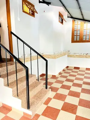 a staircase in a room with a checkered floor at Homestay Guruvayur, 1 AC & 1 Non AC bedroom in Guruvāyūr