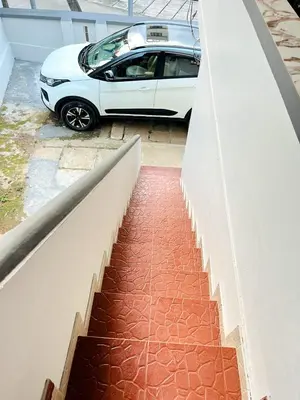 a white car is parked next to a wall at Homestay Guruvayur, 1 AC & 1 Non AC bedroom in Guruvāyūr