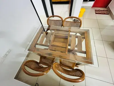 a glass table with four chairs around it at Sunrise Boutique Villa in Kozhikode
