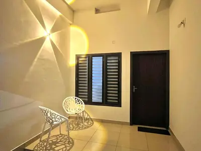 two chairs and a table in a room with a window at Sunrise Boutique Villa in Kozhikode