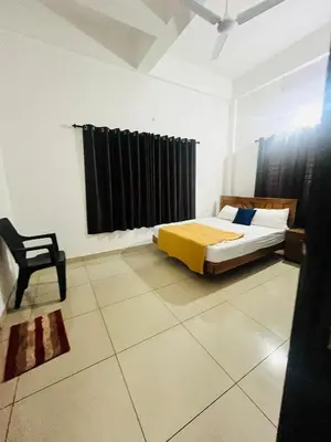 a bedroom with a bed and a chair in it at Sunrise Boutique Villa in Kozhikode