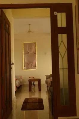 a living room with a picture of a woman on the wall at 2BHK City View Calicut in Kozhikode