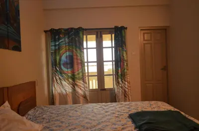 a bedroom with a bed and a window with a curtain at 2BHK City View Calicut in Kozhikode