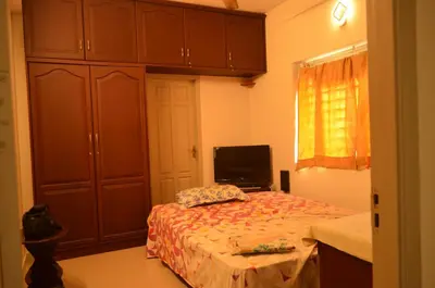 a small bedroom with a bed and a tv at 2BHK City View Calicut in Kozhikode