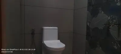 a bathroom with a white toilet in a wall at Hotel Eden Palace in Trichūr