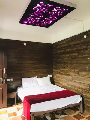 a bedroom with a large bed with a purple ceiling at Coorg Sana Riverside in Suntikoppa