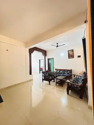 a living room with couches and a table at Coorg Sana Riverside in Suntikoppa