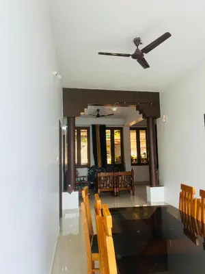a dining room with chairs and a ceiling fan at Coorg Sana Riverside in Suntikoppa