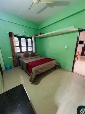 a bedroom with a bed in a green wall at Coorg Sana Riverside in Suntikoppa