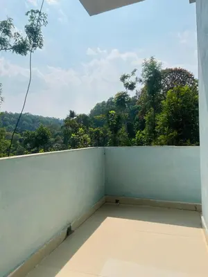 a balcony with a view of the forest at Coorg Sana Riverside in Suntikoppa