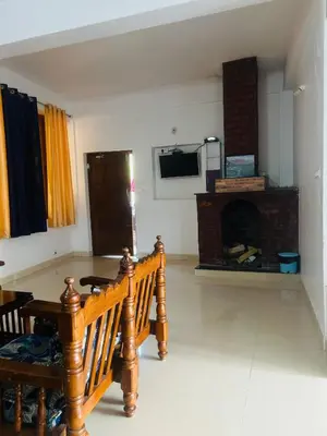 a living room with a couch and a fireplace at Coorg Sana Riverside in Suntikoppa