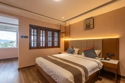 a bedroom with a large bed and a window at Serenity Suites in Ooty