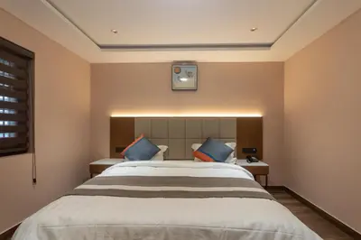 a bedroom with a large bed with blue pillows at Serenity Suites in Ooty