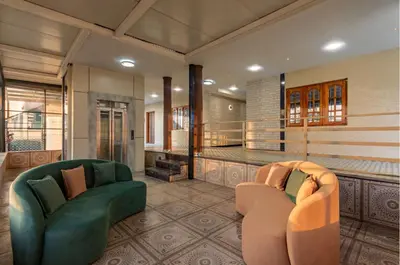 a living room with two chairs and a balcony at Serenity Suites in Ooty