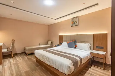 a bedroom with a bed and a desk and a chair at Serenity Suites in Ooty