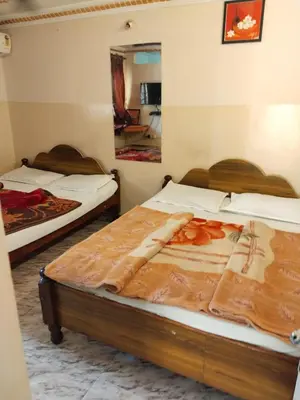 two beds in a room with a mirror at NKF Residency mysuru in Mysore