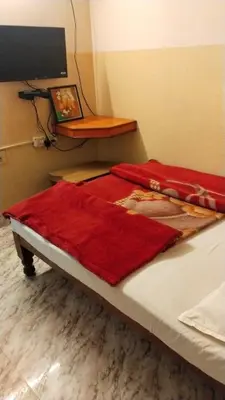 a bed with a red blanket on top of it at NKF Residency mysuru in Mysore