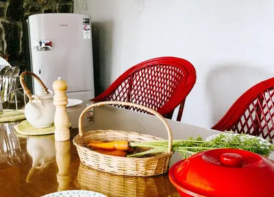 a table with a basket of vegetables on it at Manas Valley View bungalow by Xacro Xperiences in Kodaikānāl