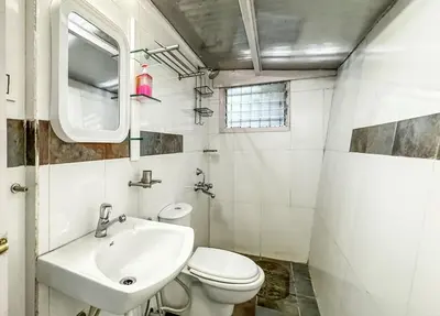 a white bathroom with a sink and a toilet at Manas Valley View bungalow by Xacro Xperiences in Kodaikānāl