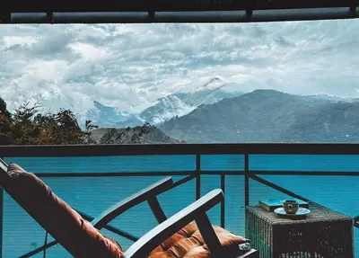 a chair on a balcony with a view of the mountains at Manas Valley View bungalow by Xacro Xperiences in Kodaikānāl